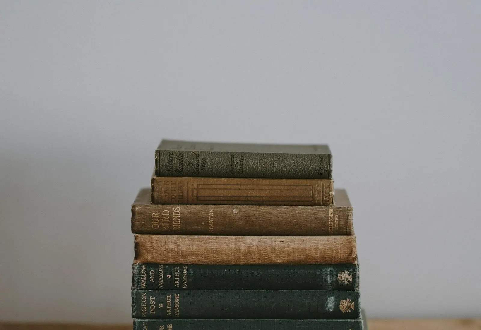 A stack of bound volumes on a wooden shelf