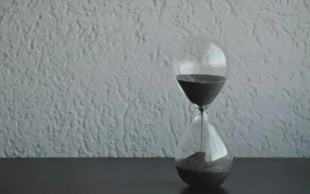 An hourglass, with sand running through