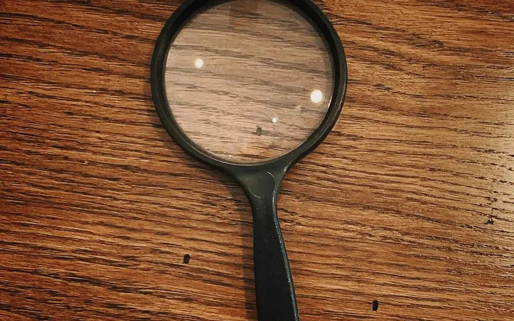 A magnifying glass on a wooden desk