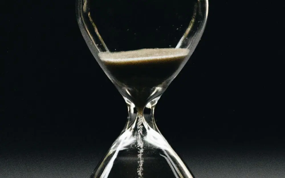 An hourglass against a dark ground